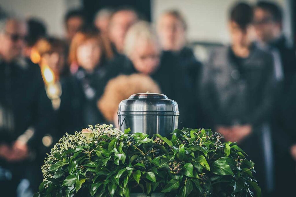 A respectful indoor setting with a simple urn on a table, surrounded by flowers and family photographs.