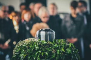 A respectful indoor setting with a simple urn on a table, surrounded by flowers and family photographs.