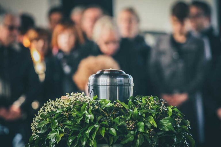 A respectful indoor setting with a simple urn on a table, surrounded by flowers and family photographs.