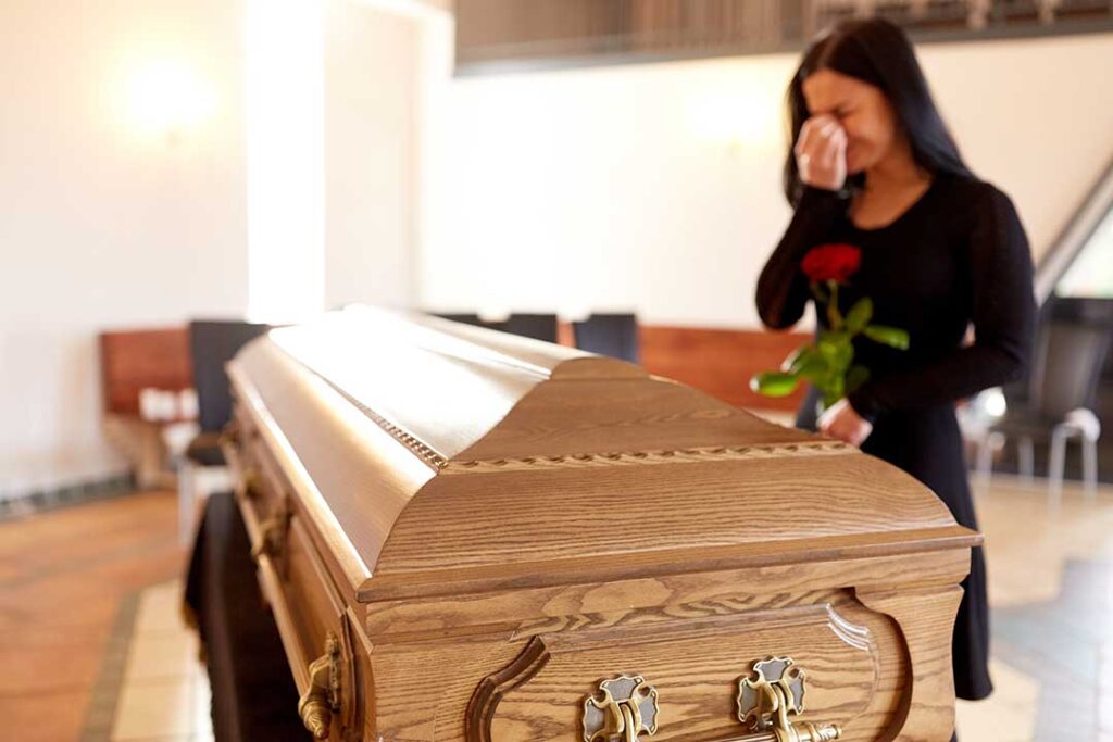 Family members arrange photographs, flowers, and handwritten memories on a home memorial table.