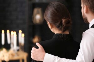 Family members review written funeral preferences and important documents together at a dining table.